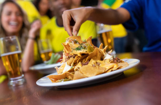 Close up on nachos at a sports bar Close up on nachos at a sports bar while friends are watching a game nacho chip stock pictures, royalty-free photos & images