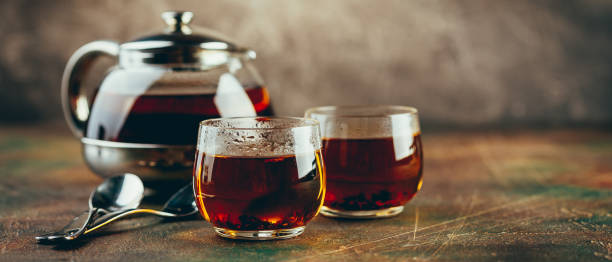 istock Transparent glass teapot black tea and glass cups 1128065512