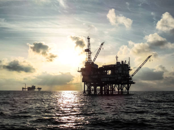 piattaforma petrolifera offshore al tramonto. - oil rig oil sea mining foto e immagini stock