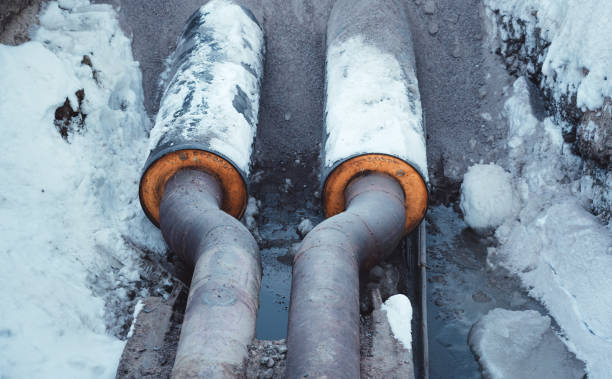 istock Two welded steel pipes with insulation in a snowy trench 1128068156