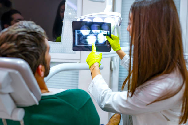 istock Female dentist explaining x-ray image to patient. 1128070346