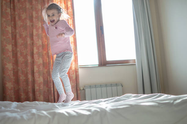 istock Beautiful girl jumping on the bed 1128070873