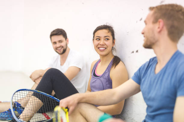 trois adversaires prenant une pause dans leur jeu de squash - racketball racket ball court photos et images de collection