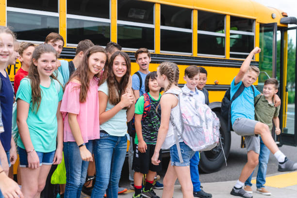 istock Portrait of elementary students next to a school bus 1128073435