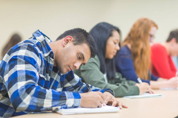 istock College students studying at desks in a lecture hall 1128073863