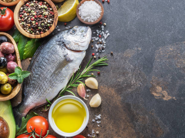 istock Raw dorado fish with spices and vegetables. 1128074329