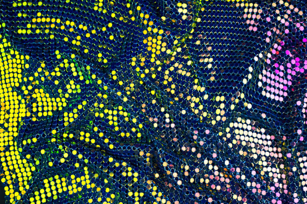 istock Abstract background with gold, green and purple sequins on the fabric. 1128076938