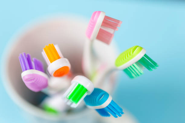 toothbrushes close up shot of toothbrushes in a cup on a blue background toothbrush stock pictures, royalty-free photos & images
