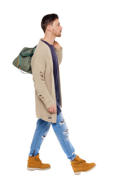 istock back view of walking  man  with green bag. 1128078643