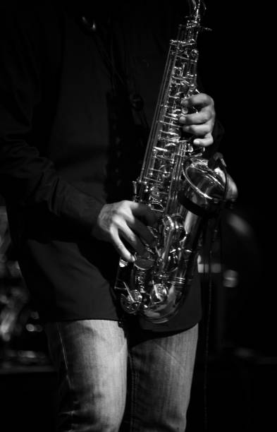 istock Midsection Of Man Playing Saxophone In Darkroom 1128080010