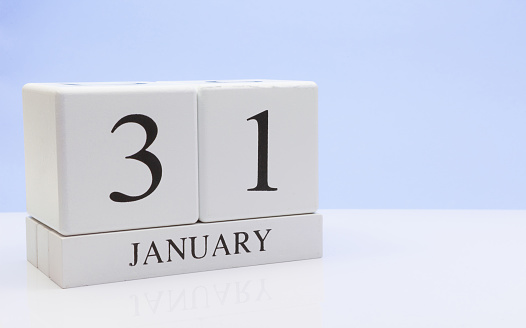 January 31st. Day 31 of month, daily calendar on white table with reflection, with light blue background. Winter time, empty space for text