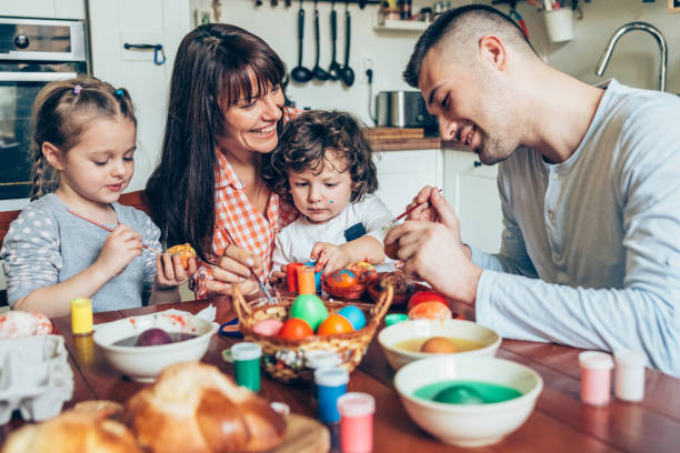 istock Happy family painting Easter eggs 1128083710