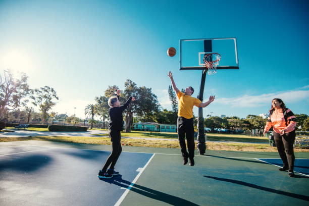 madre latina con hijos adolescentes jugando baloncesto - miami basketball fotografías e imágenes de stock