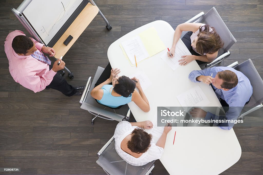 4 つのビジネスマンのボードルームテーブルのプレゼンテーションの眺め - フリップチャートのロイヤリティフリーストックフォト