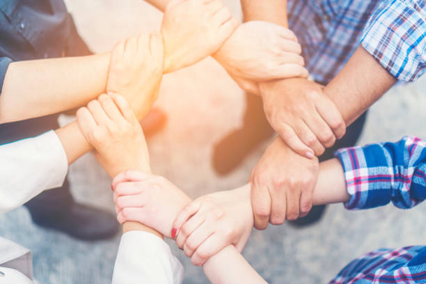 istock Low Section Of Friends Holding Hands On Footpath 1128090010