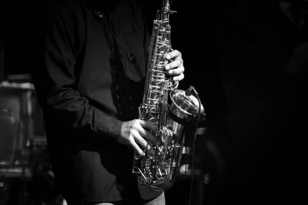 istock Midsection Of Man Playing Saxophone In Darkroom 1128090590