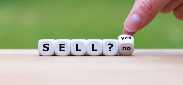 istock Time to sell? Hand turns a dice and changes the word 