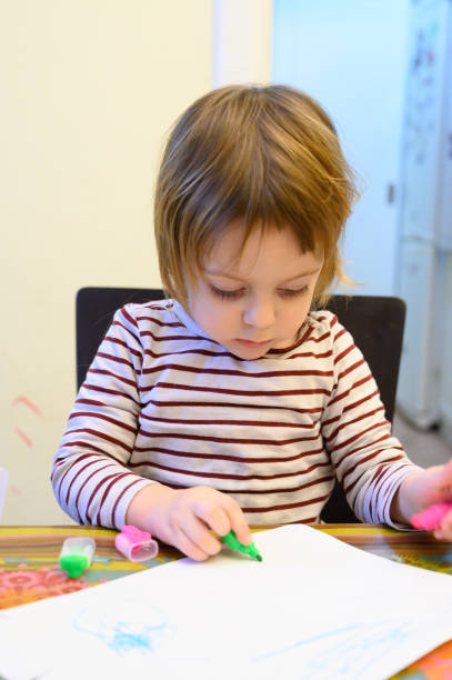 istock Little girl drawing at home 1128099632