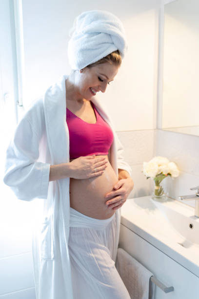 istock Pregnant woman applying moisturizer on her belly 1128099767