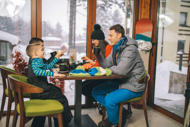 istock Family drinking hot tea after skiing 1128101357