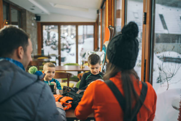 istock Family drinking hot tea after skiing 1128101424