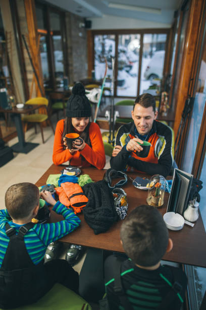 istock Family drinking hot tea after skiing 1128101453