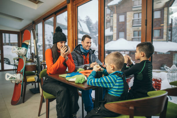 Family drinking hot tea after skiing