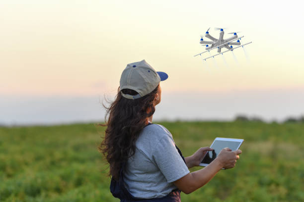 jeune agricultrice, pulvérisant ses cultures à l’aide d’un drone - aerial view mid air farm field photos et images de collection