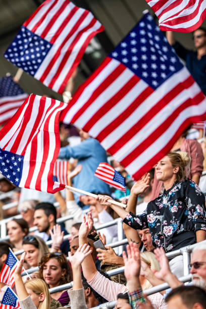 istock Woman waving a US flag on a stadium 1128114563