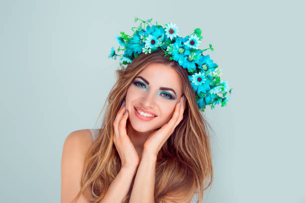 istock woman with floral crown on head looking at camera smiling 1128119270