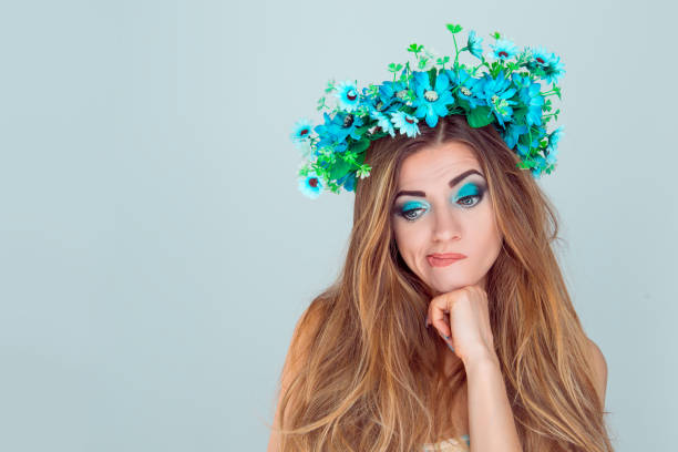 istock puzzled upset young Woman with floral headband looking down 1128119285