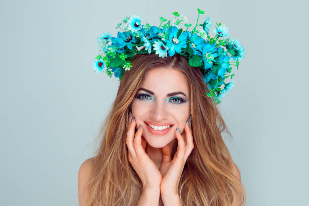 istock woman with floral crown on head looking at camera smiling 1128119287