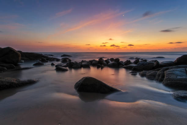 istock Beautiful sunset on the beach with rock 1128127218