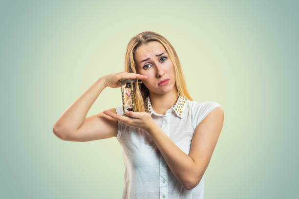 istock Hopeful woman looking at hourglass 1128130533