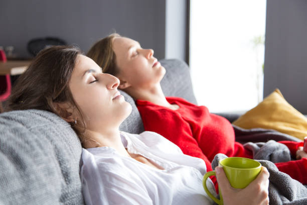 istock Two girls resting on couch 1128131970