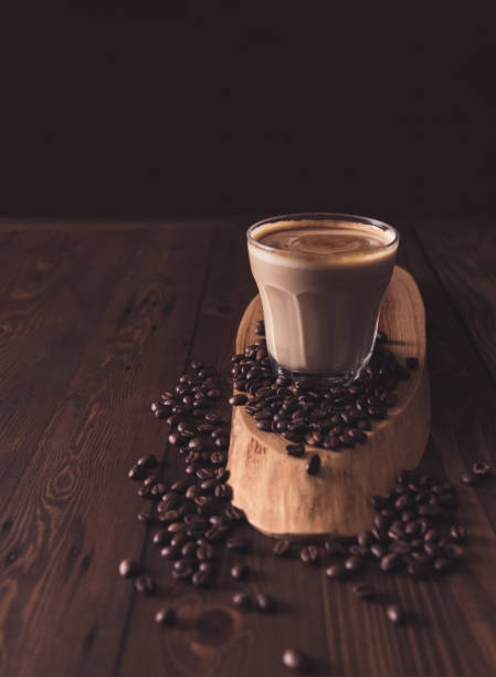 istock Coffee Latte Flat white in a glass with coffe beans spread out on a wooden table. 1128140583