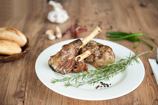 Roast Leg of Lamb on the plate on wooden table