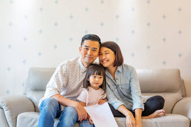 istock Mother and Father With a Child on the Sofa 1128148964