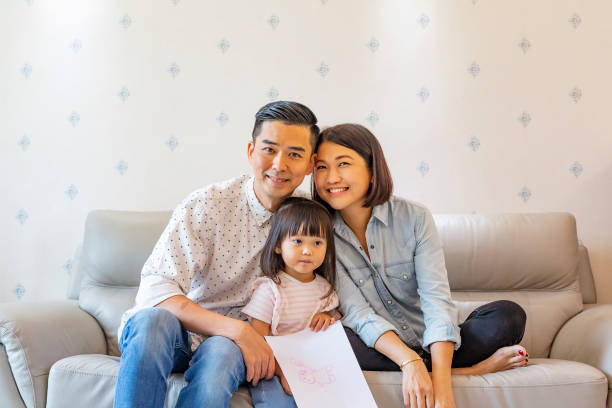 istock Mother and Father With a Child on the Sofa 1128148967
