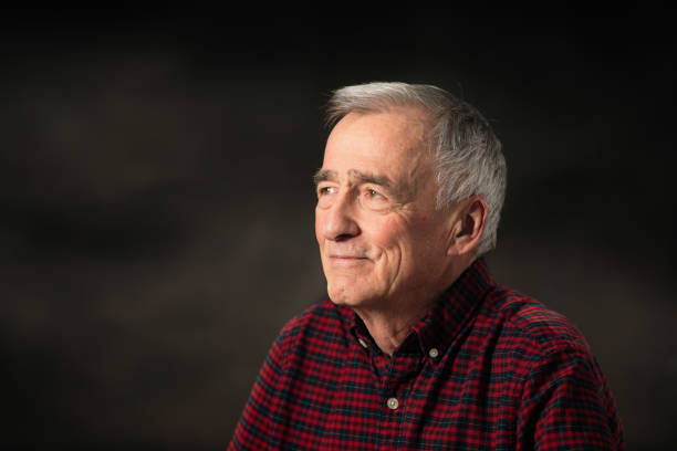 Close-up of a smiling businessman standing at isolated barckround while looking at you.