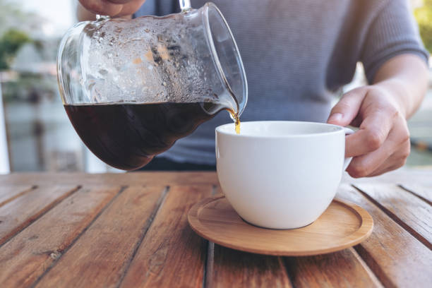 istock hand pouring drip coffee into a white mug 1128152957