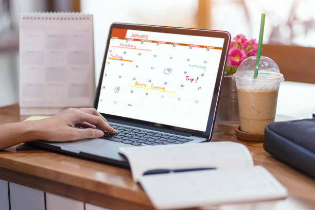 istock Woman planning agenda and schedule using calendar event planner. Woman hands using plan to vacation on computer laptop. Calender planner organization management remind concept. 1128156063