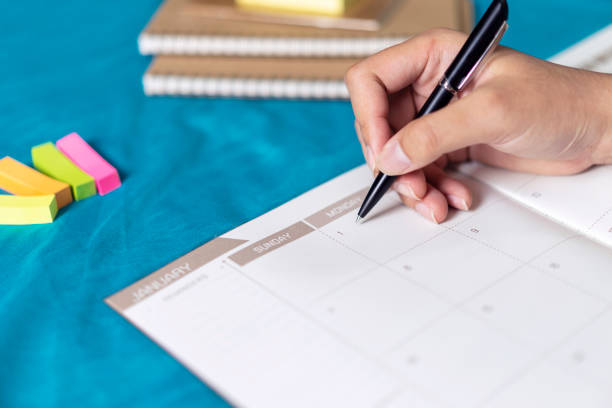 istock Woman planning agenda and schedule using calendar event planner, Writing plan on memo scheduled, planned to vacation weekend. 1128156070