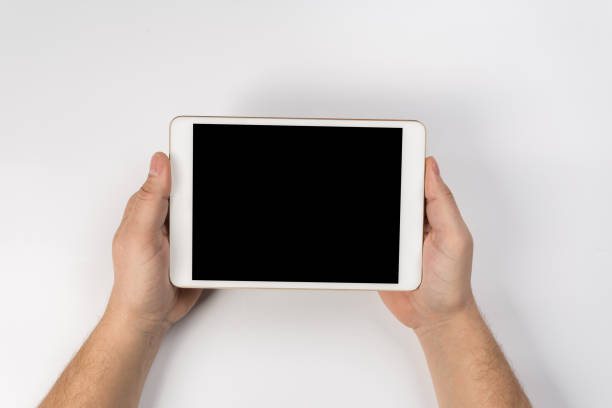 istock Hand touch on empty screen of tablet above brown table top view, Leave space for display of your content, Technology concept, mock up for montage your content 1128159716