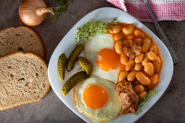 istock Beans with smoked pork meat, eggs and pickles on plate 1128160006