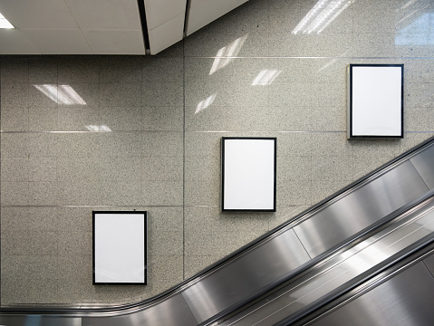 Cartelera en blanco en la estación de metro con escaleras mecánicas. photo