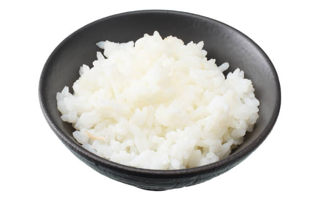 istock White rice in black bowl isolated on white background. 1128161747