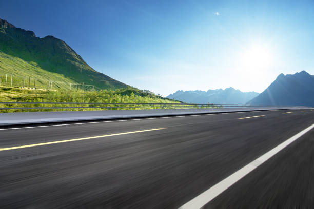 route de montagne sinueuse sans voitures - winding road sunlight field cultivated land photos et images de collection