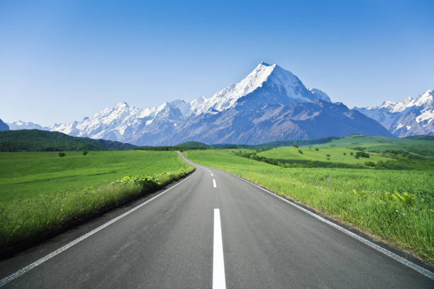 route de montagne sinueuse sans voitures - winding road sunlight field cultivated land photos et images de collection