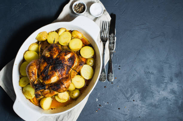 istock Grilled chicken with a side dish of potatoes. Dark background, top view, space for text 1128165115
